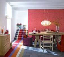 Striped carpet on stairs with dining table against red wall
