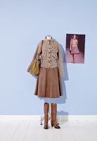 Sweater and leather skirt on mannequin with bag and boots