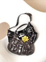 Black and grey handbags with buckles and yellow painted flower on it