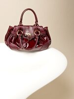 Wine red leather bag with leather inserts, padlock and heart pendant