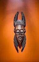 African wooden mask on orange background