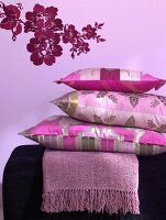 Three pillows in pink-purple and plaid stacked on each other