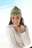 Portrait of beautiful woman wearing white cardigan and green knit cap, smiling widely
