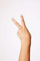 Hand, Mittelfinger und Zeige- finger zu einem V ausgestreckt