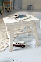 White wooden stool with toy cars