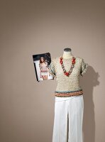 Short sleeve sweater and white pants on mannequin