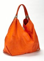 Close-up of orange handbag on white background