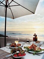 Table laid with food dishes and wine glasses on terrace restaurant, Portugal