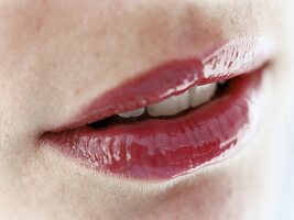 Rote Lippen mit farblosem Lipgloss, close up