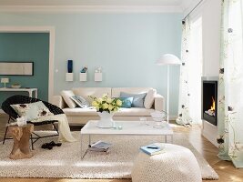 Wohnzimmer mit weissen Möbeln und hellblauer und türkisfarbener Wand