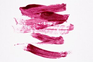 Shades of pink lipstick stripes on white background 