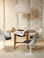 Dinning area with chair, hanging lamp and 60's style wallpaper patterned