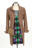 Suede jacket with stand-up collar and silk dress with graphic pattern on white background