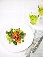 Rosti with braised root vegetables and herbs on plate