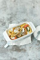 Macaroni gratin with grilled vegetables on serving dish
