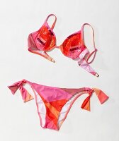 Pink-orange patterned bikini with sequins against white background