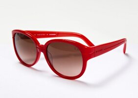 Close-up of red plastic frame sunglasses on white background