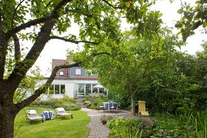 Blick über den Garten mit großer Rasenfläche zum Wohnhaus