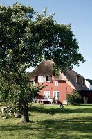 Cottage with thatched and gable roof with garden in front