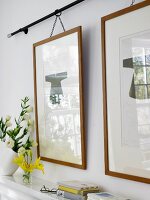 Kimono images in wooden frame hanging on curtain rod against wall