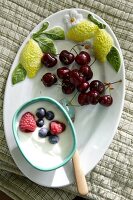 Cherries and buttermilk cream on ceramic plate