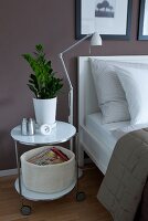 Weißer Nachttisch mit Zimmerpflanze, Stehleuchte, Bett
