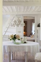 Weißes Esszimmer mit PorzellanLüster, Tür zum Schlafzimmer