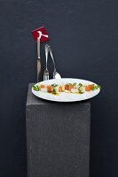 Corn-fed chicken breast with vegetables, herb sauce and squid mayonnaise on plate