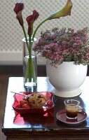 Beistellstich mit Blumen, Schale mit Muffin und Espressotasse