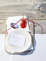 Paper note in bowl with lobster and spoon on tray
