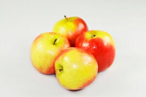 Close-up of four apples on white background