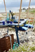 Outdoor-Möbel: Gartentisch mit aufge stecktem Sonnendach am Strand