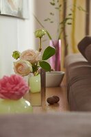 Close-up of pink rose in vase on wooden floor