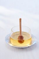 Glas mit Honig und Honiglöffel 