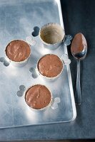 Chocolate souffle being made: chocolate mixture being transferred into ramekins