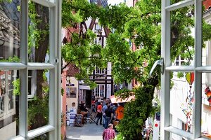 View of people on Schnoor street in Viertel through window, Bremen, Germany