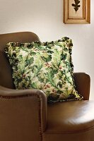 Pillow with oak leaves pattern on brown sofa