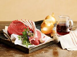 An arrangement featuring a saddle of lamb, beef, onions, herbs and red wine