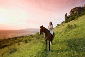 Woman with horse standing on mountain slope in Franconian Switzerland, Bavaria, Germany