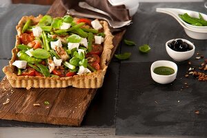 Tomato tart with cream cheese, herbs and lemon salsa on wooden board