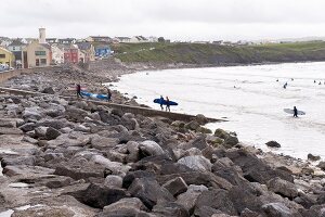 View of surfers and rocks at Lahinch Co Clare beach, Ireland, UK