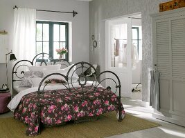 Iron bed with rose plaid blanket in room