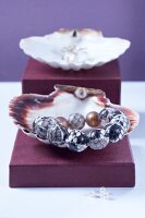Close-up of empty scallop shell with pearl necklace