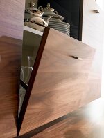 Close-up of open hinged door of sideboard