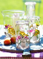 Weckglas als Windlicht, dekoriert mit Blumen und Wasser