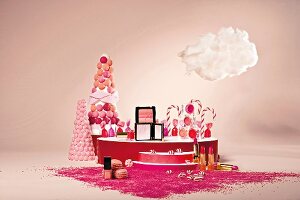 Kosmetikartikel und Süßigkeiten in rosa-rot-Tönen