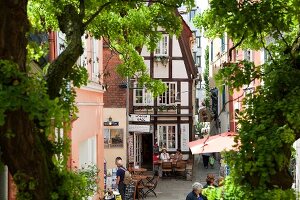 View of people on Schnoor street in Viertel through window, Bremen, Germany