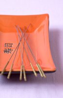 Acupuncture needles in an orange and black tray