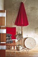 Red umbrella, cushions and table as garden furniture inside room