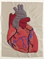 Close-up of human heart sewn on fabric